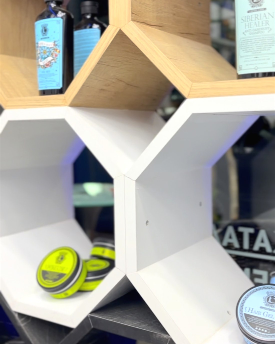 Τα εξαγωνικά ράφια με τα προϊόντα περιποίησης στο Infinity Barber Shop